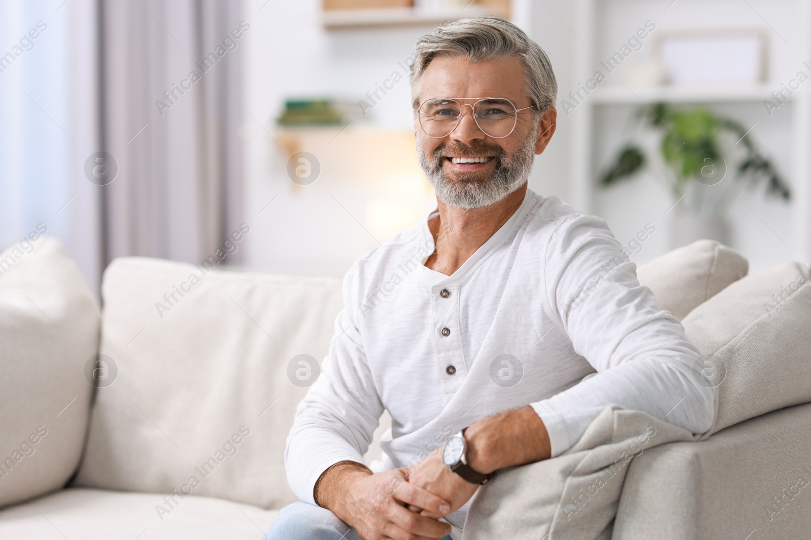 Photo of Portrait of happy middle aged man on sofa at home