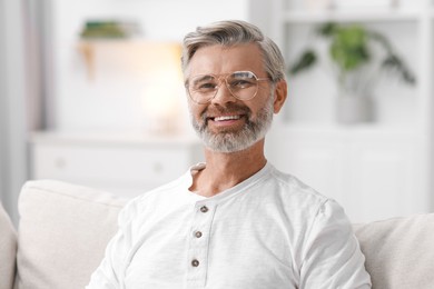 Photo of Portrait of happy middle aged man on sofa at home