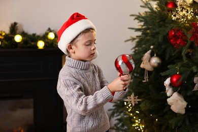 Photo of Little boy with Christmas ornament at home