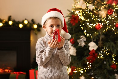 Photo of Little boy with Christmas ornament at home