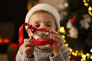 Photo of Little boy with Christmas ornament at home