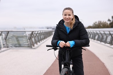 Woman with bicycle outdoors, space for text