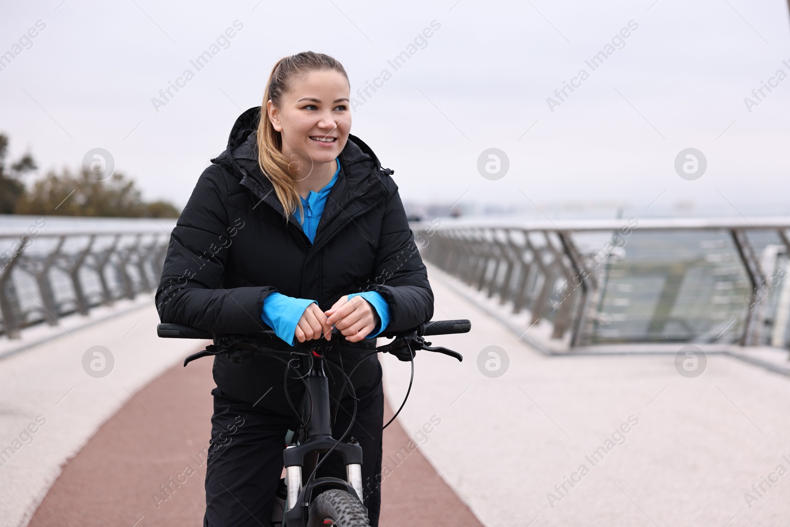 Photo of Woman with bicycle outdoors, space for text