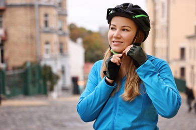 Photo of Woman with helmet and bicycle outdoors, space for text