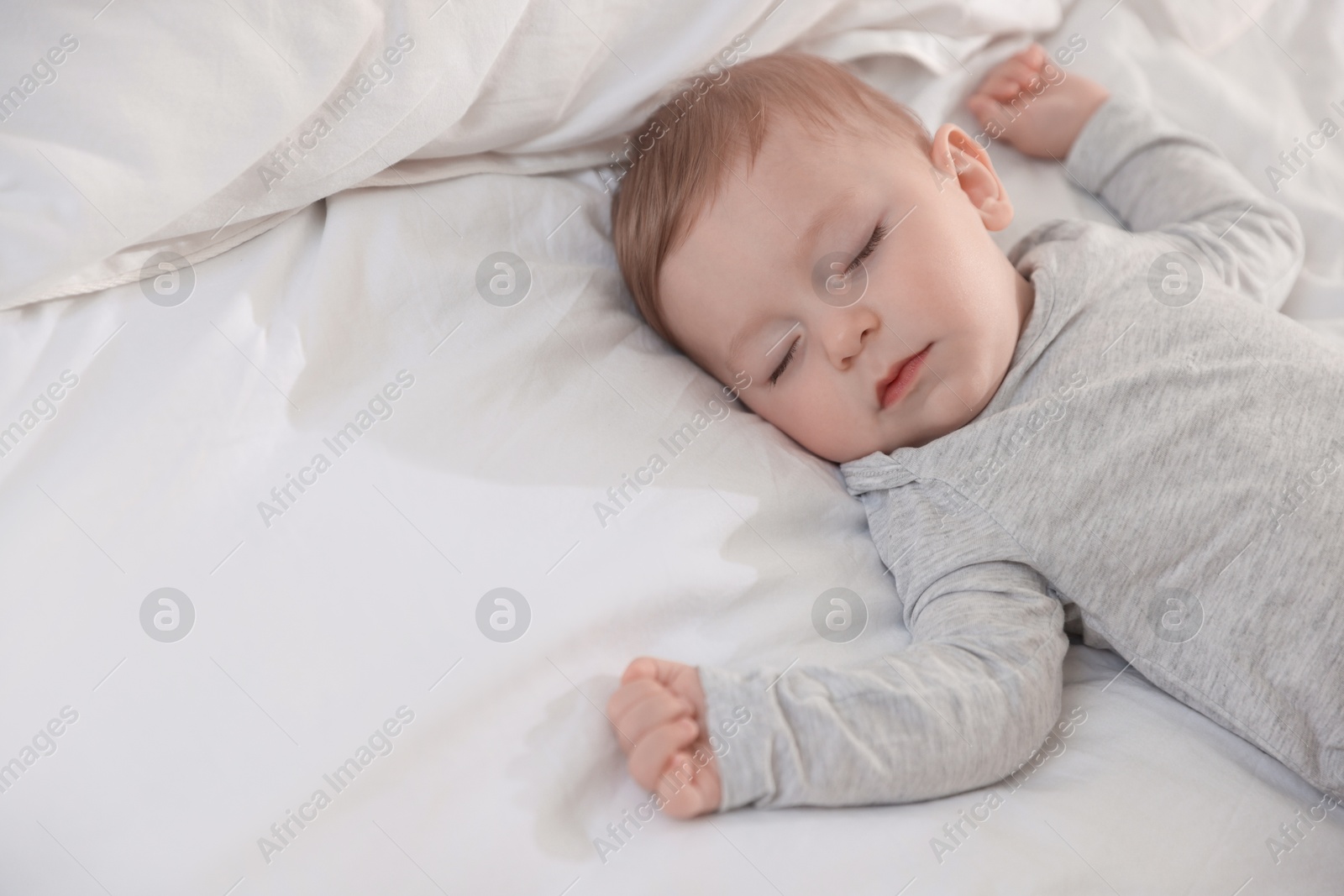 Photo of Cute little baby sleeping on bed at home, space for text