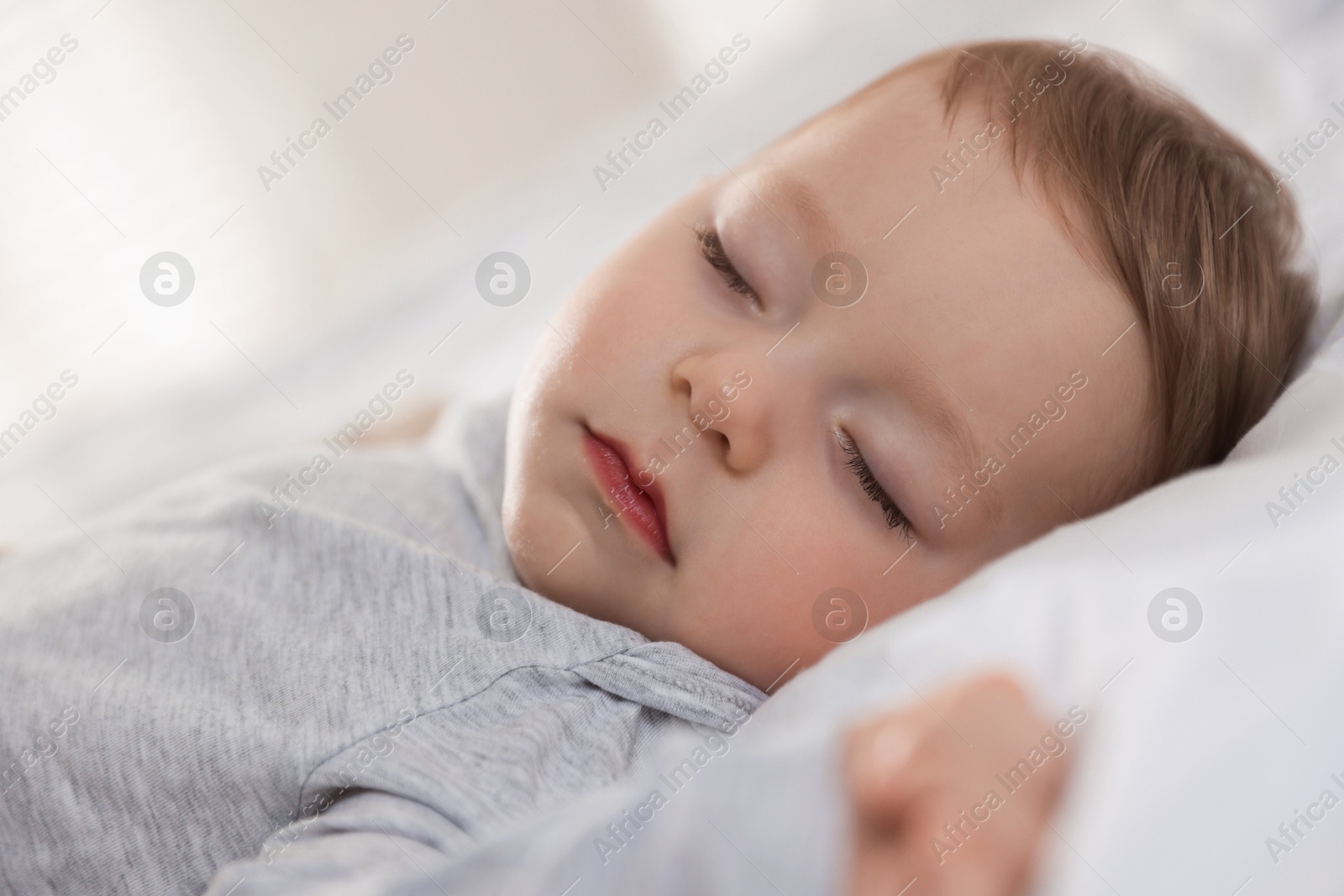 Photo of Cute little baby sleeping on bed at home, closeup