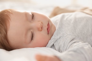 Photo of Cute little baby sleeping on bed at home, closeup