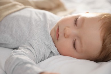 Photo of Cute little baby sleeping on bed at home, closeup