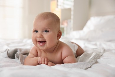 Photo of Cute little baby lying on bed indoors