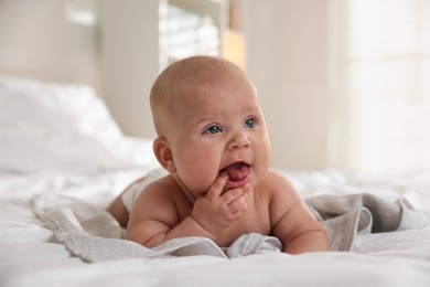 Photo of Cute little baby lying on bed indoors