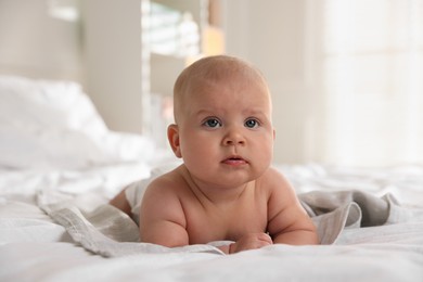 Photo of Cute little baby lying on bed indoors