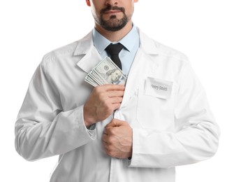 Photo of Corruption concept. Doctor putting dollar banknotes into his coat on white background, closeup