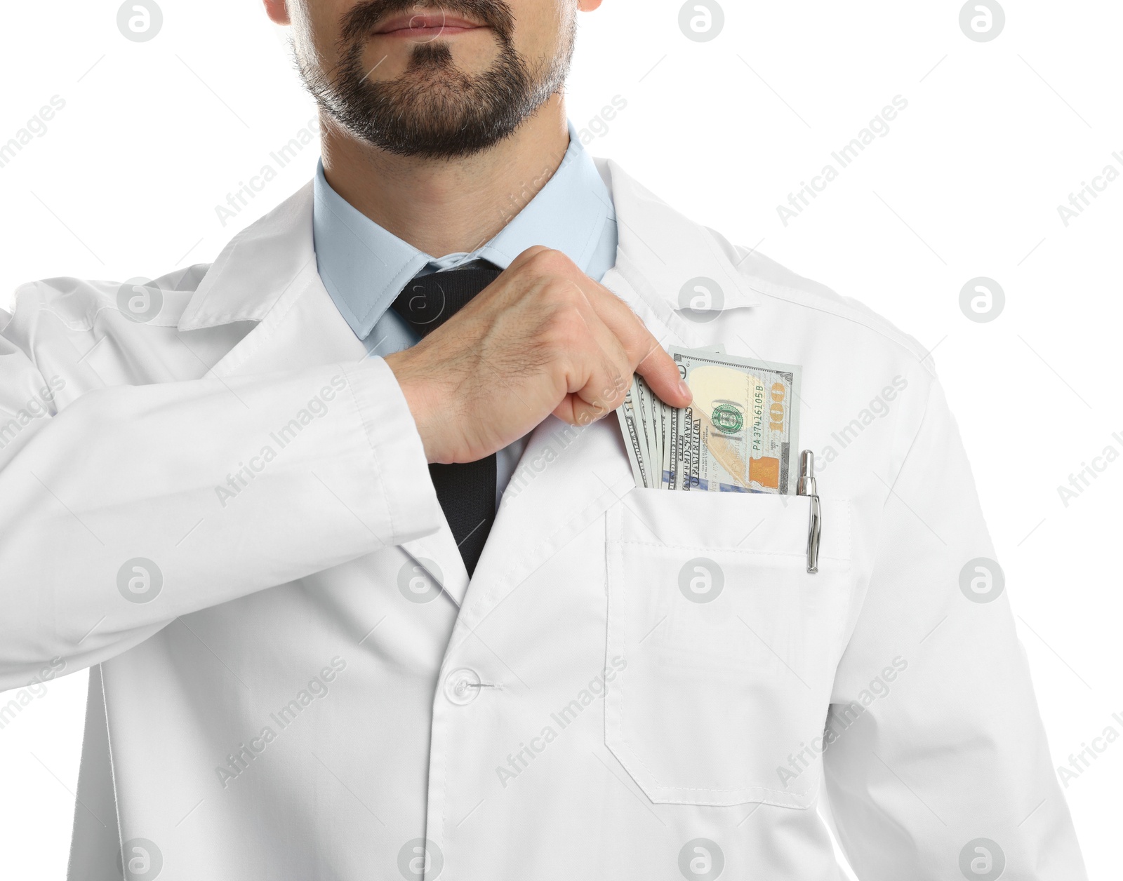 Photo of Corruption concept. Doctor putting dollar banknotes into his pocket on white background, closeup