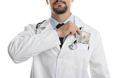 Photo of Corruption concept. Doctor putting dollar banknotes into his pocket on white background, closeup