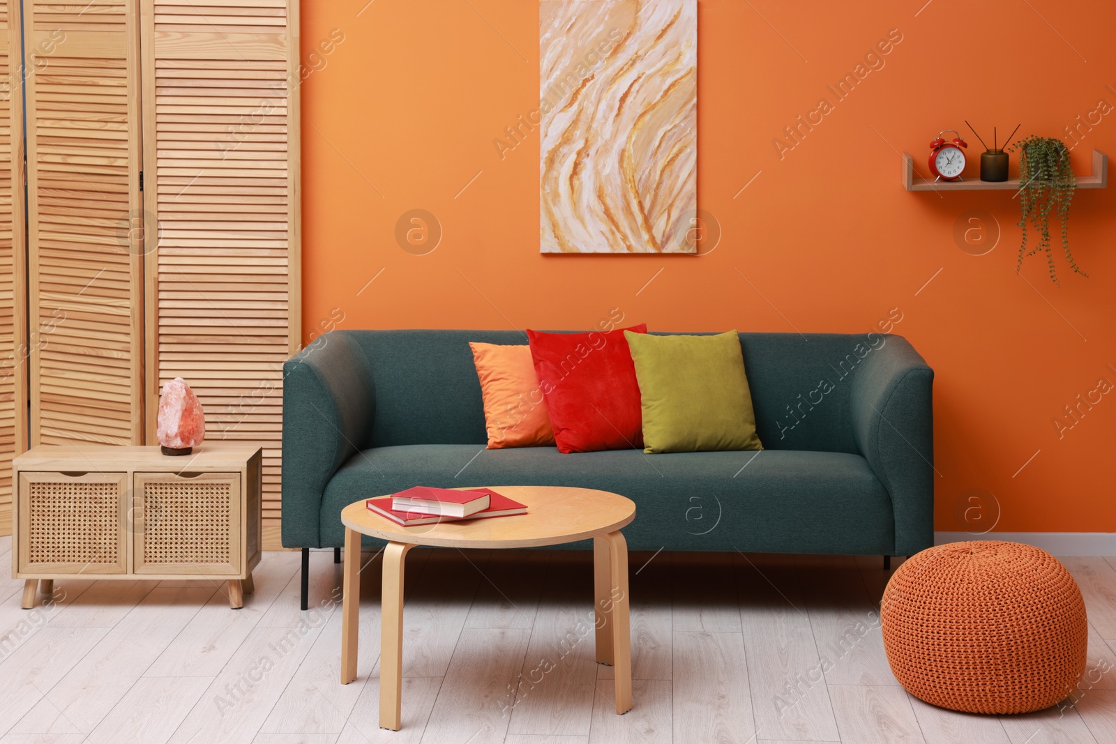 Photo of Stylish living room interior with comfortable sofa near orange wall