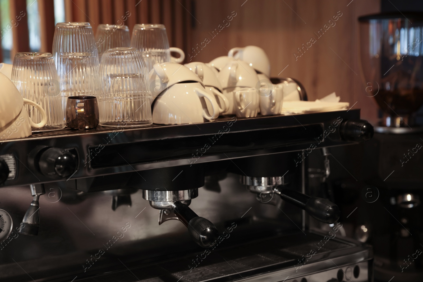 Photo of Professional coffee machine and cups in cafe, closeup