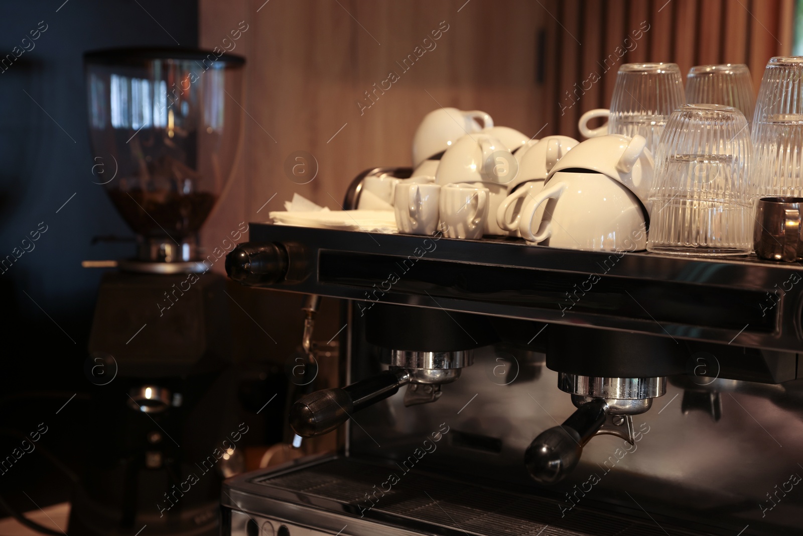 Photo of Professional coffee machine and cups in cafe, closeup