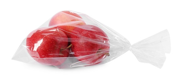 Photo of Plastic bag with red apples isolated on white