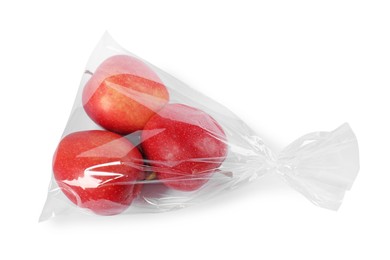 Photo of Plastic bag with red apples isolated on white