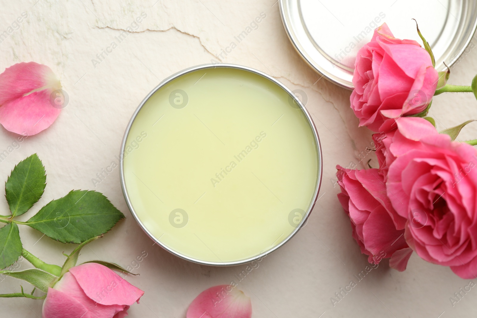 Photo of Natural solid perfume and pink roses on white textured background, flat lay