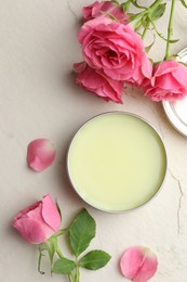 Photo of Natural solid perfume and pink roses on white textured background, flat lay