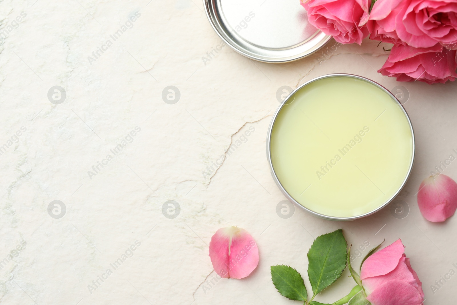 Photo of Natural solid perfume and pink roses on white textured background, flat lay. Space for text