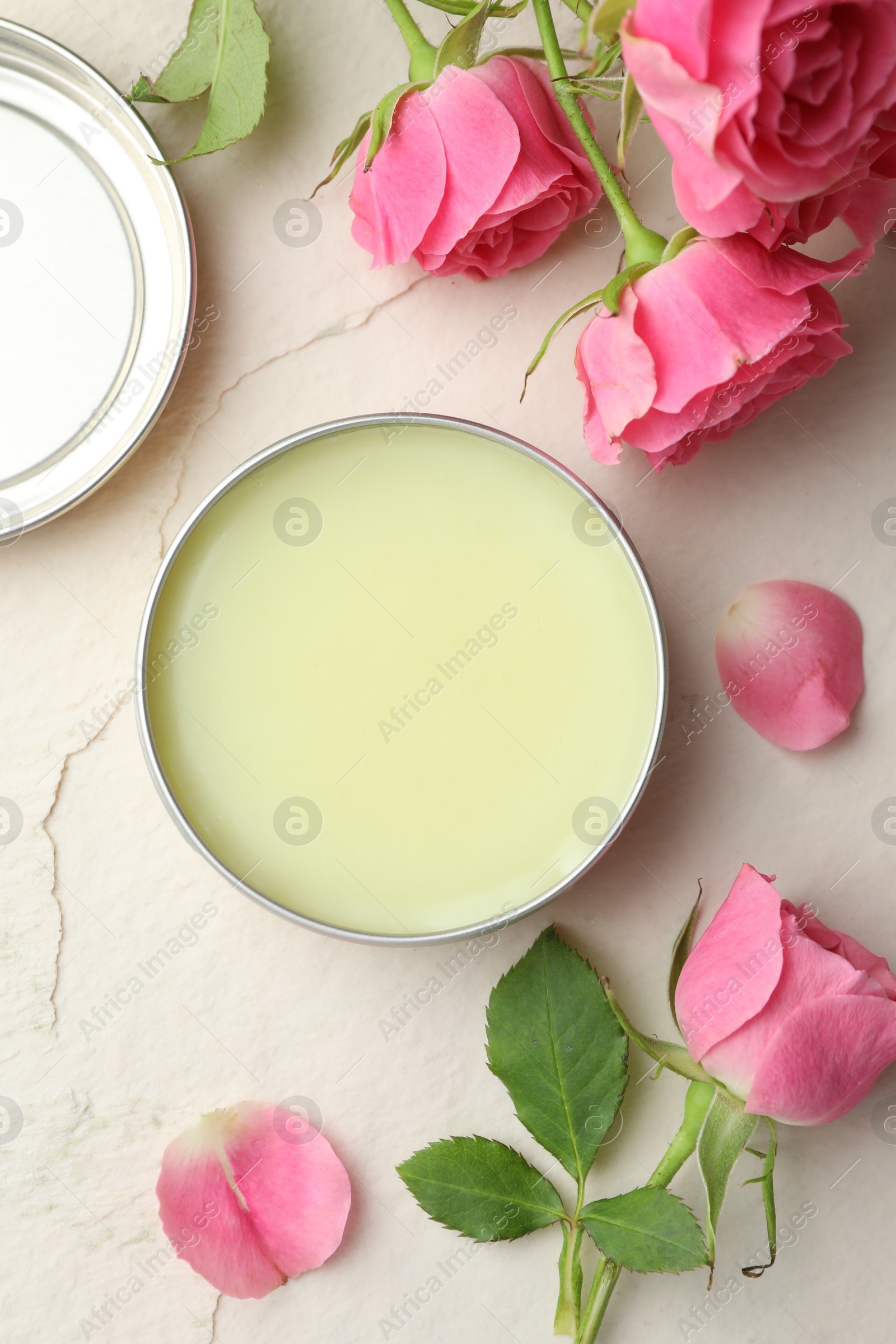 Photo of Natural solid perfume and pink roses on white textured background, flat lay