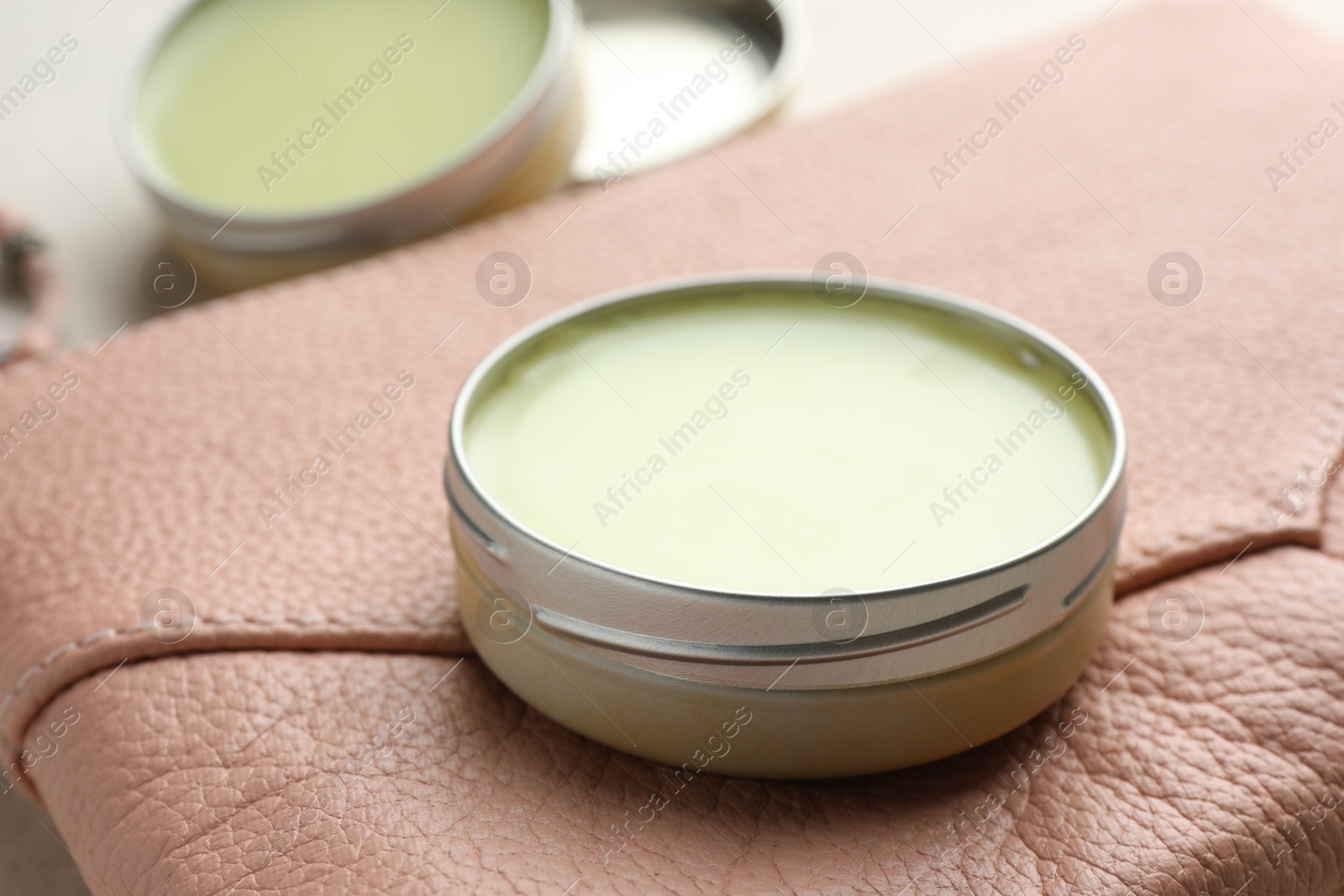 Photo of Natural solid perfume and leather bag on table, closeup