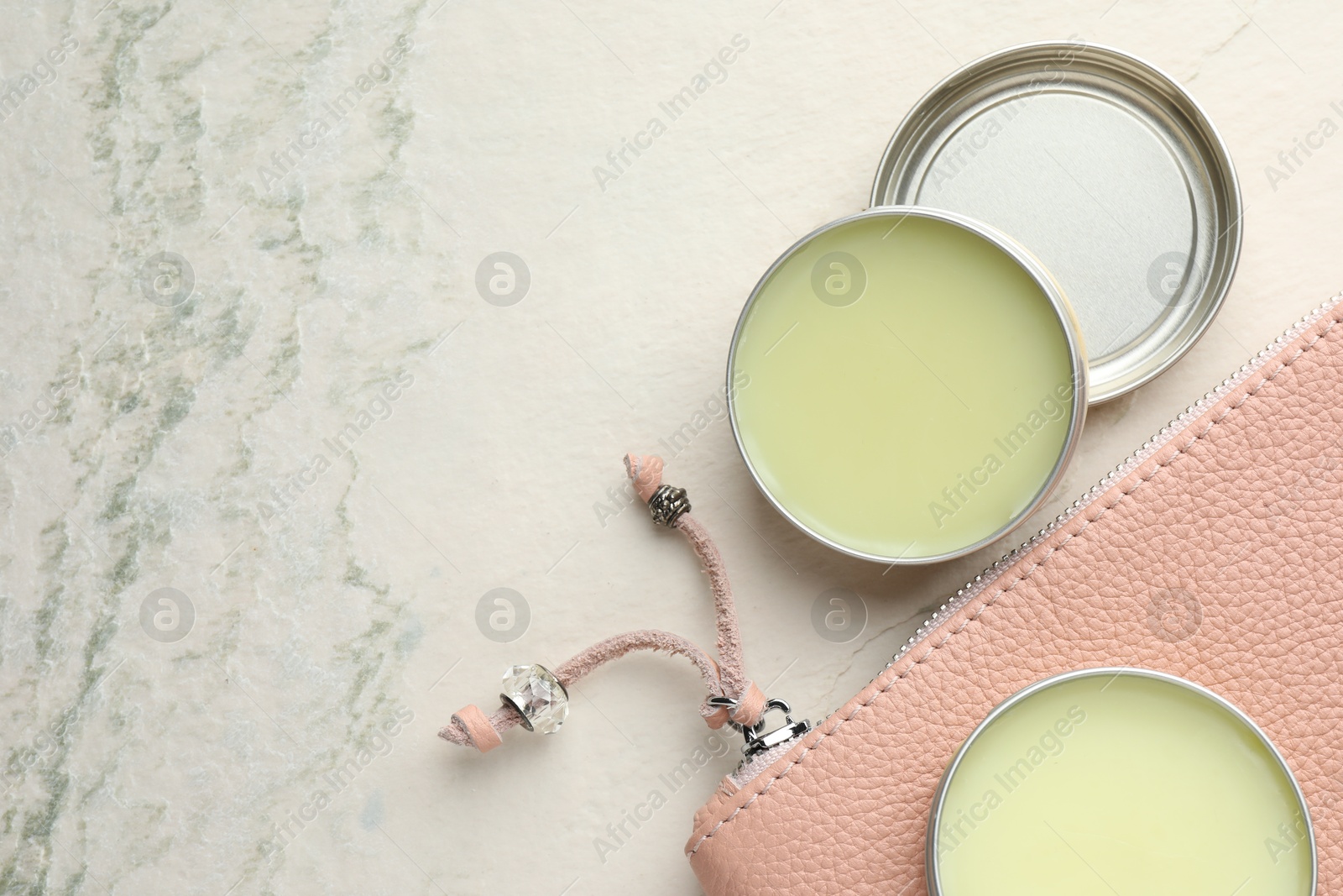 Photo of Natural solid perfume and leather bag on white textured background, flat lay. Space for text