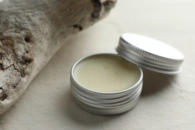 Photo of Natural solid perfume in container and snag on white table, closeup