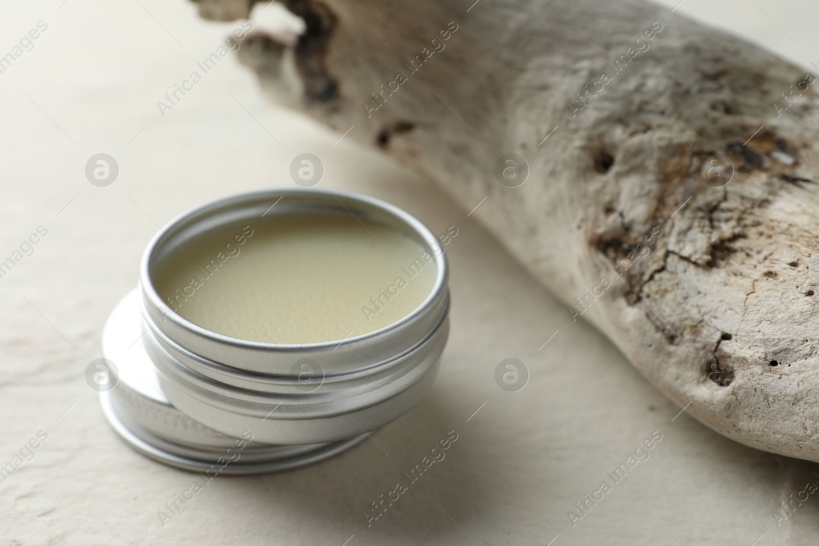 Photo of Natural solid perfume in container and snag on white table, closeup