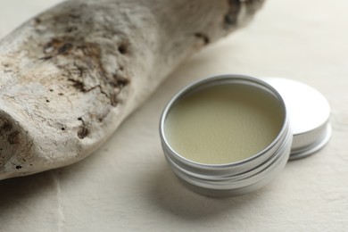 Photo of Natural solid perfume in container and snag on white table, closeup