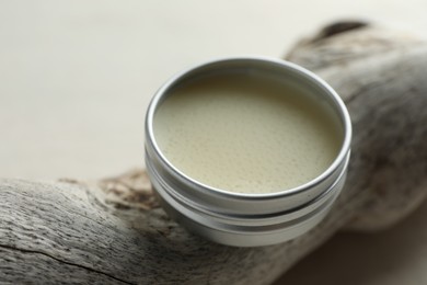 Photo of Natural solid perfume in container and snag on white table, closeup