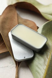 Photo of Natural solid perfume and leaves on white table, closeup