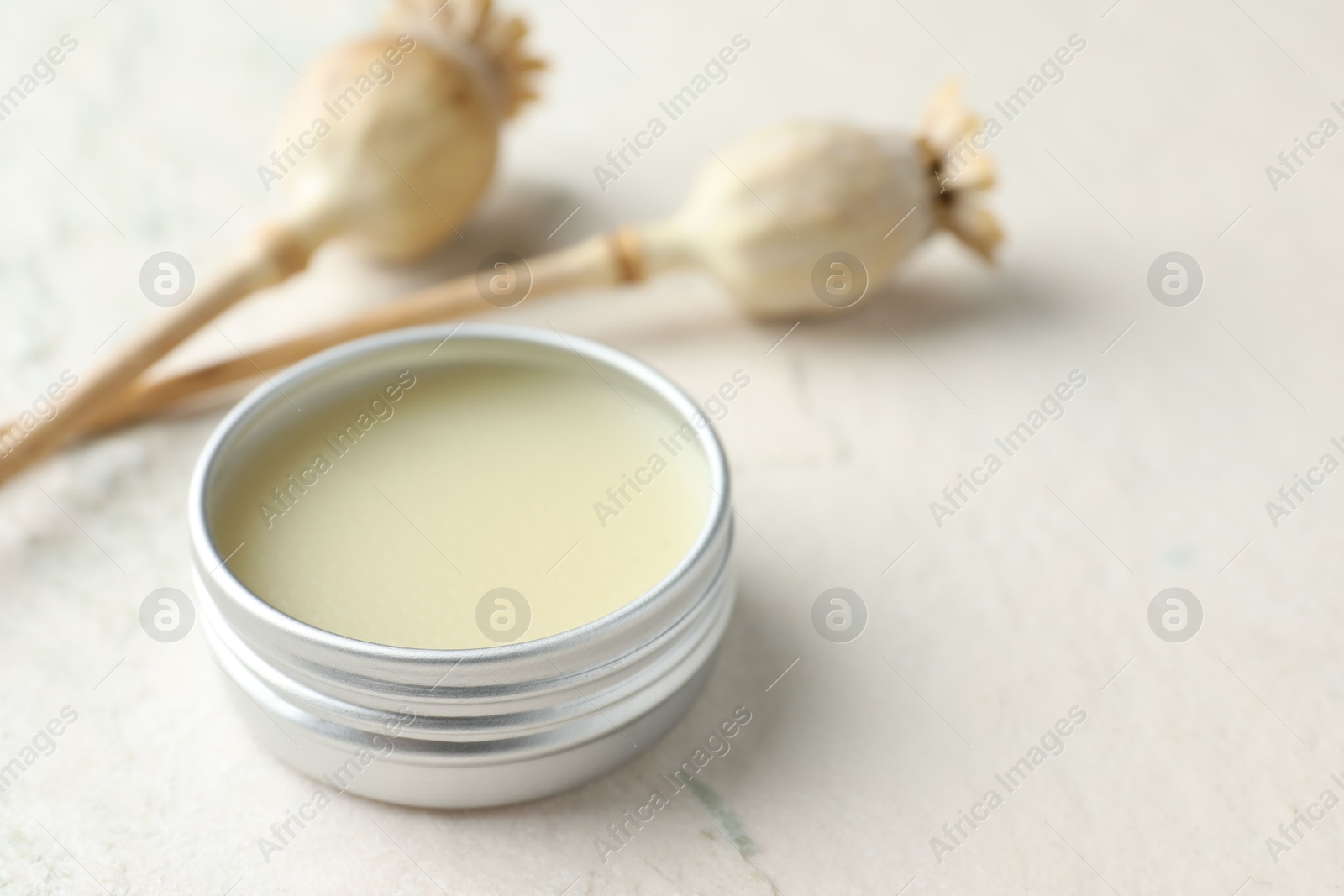 Photo of Natural solid perfume in container and plant on white table, closeup. Space for text