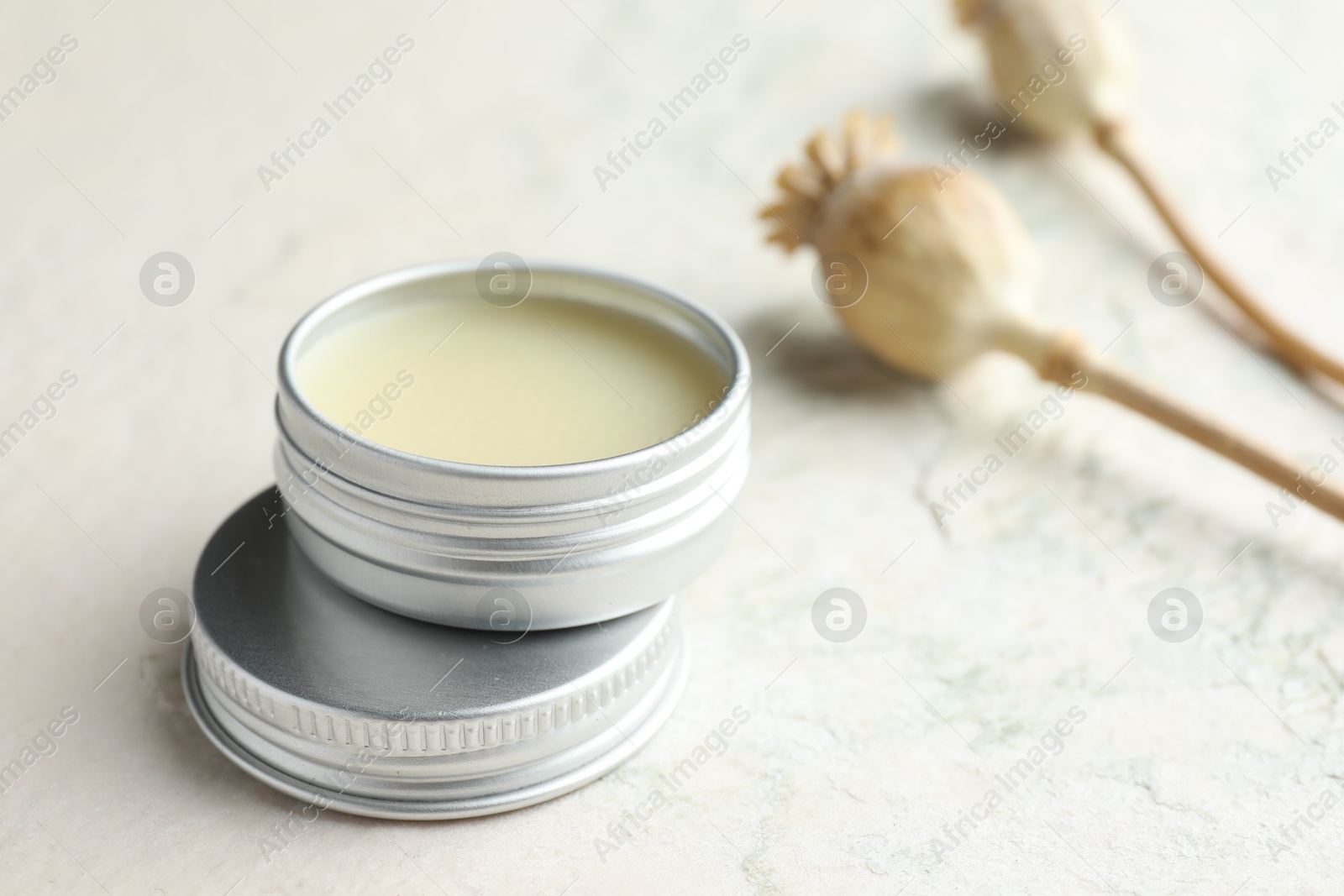 Photo of Natural solid perfume in container and plant on white table, closeup. Space for text