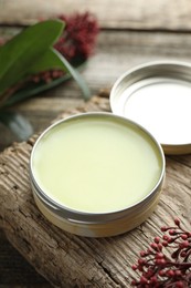 Photo of Natural solid perfume and skimmia plant on table, closeup