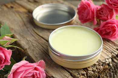 Photo of Natural solid perfume and pink roses on wood, closeup