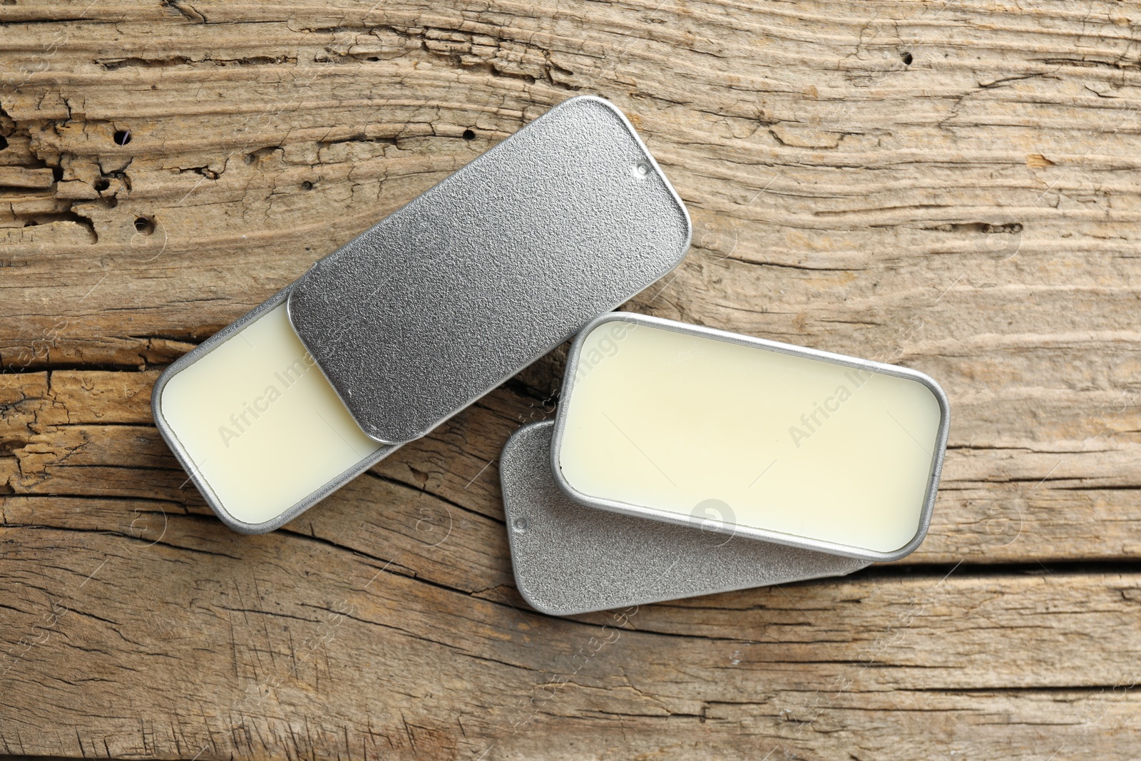 Photo of Natural solid perfume in containers on wooden table, flat lay