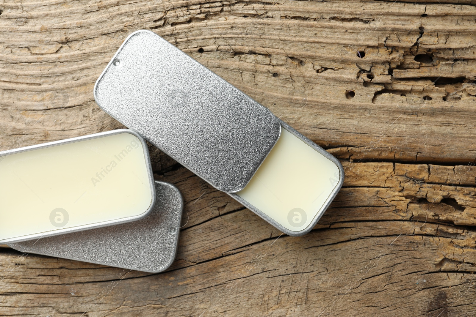 Photo of Natural solid perfume in containers on wooden table, flat lay. Space for text