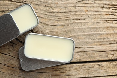 Photo of Natural solid perfume in containers on wooden table, flat lay. Space for text