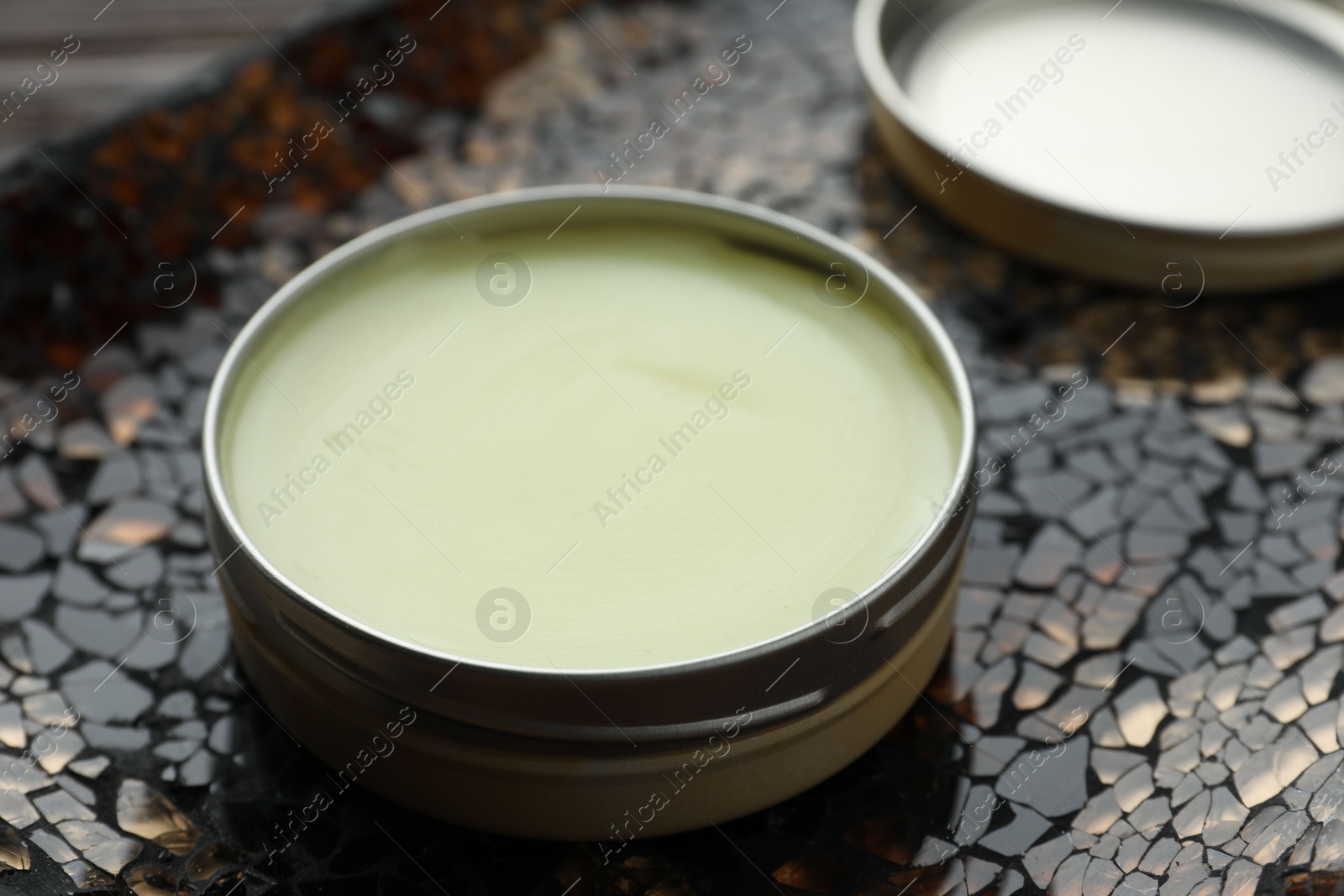 Photo of Natural solid perfume in container on surface, closeup