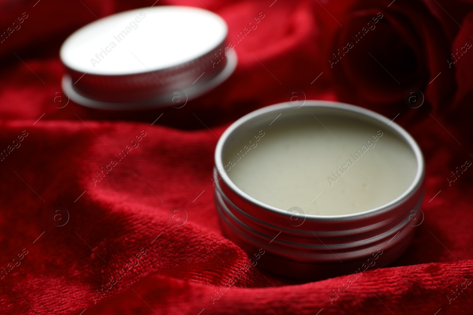 Photo of Natural solid perfume on red fabric, closeup