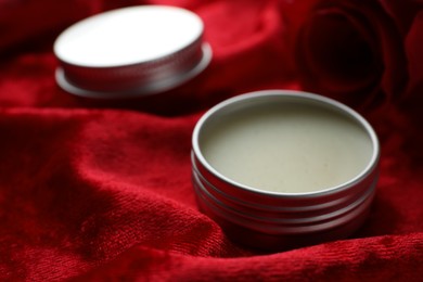 Photo of Natural solid perfume on red fabric, closeup