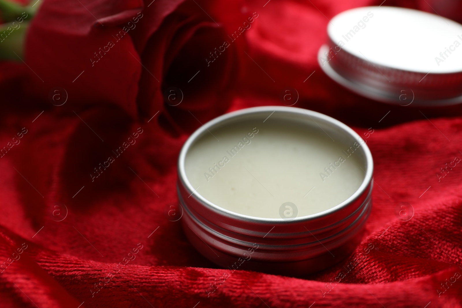 Photo of Natural solid perfume on red fabric, closeup