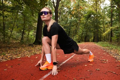 Photo of Young athletic woman stretching in park. Healthy lifestyle