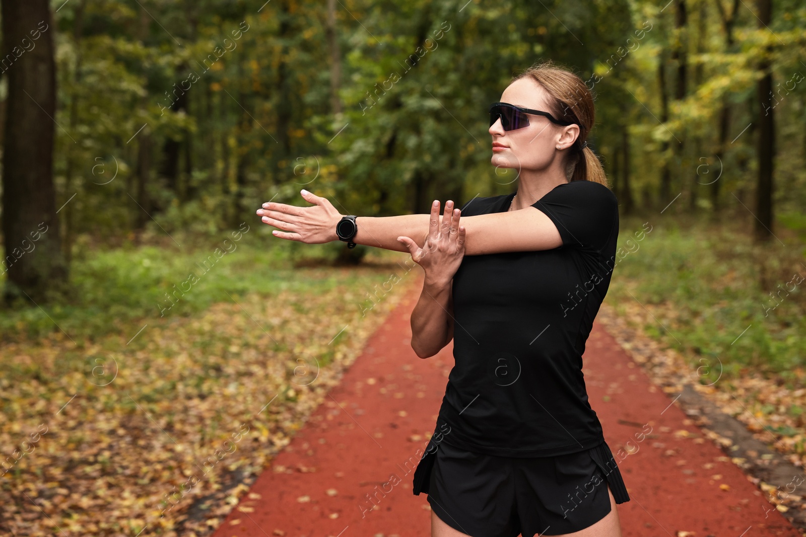 Photo of Young athletic woman stretching in park. Healthy lifestyle