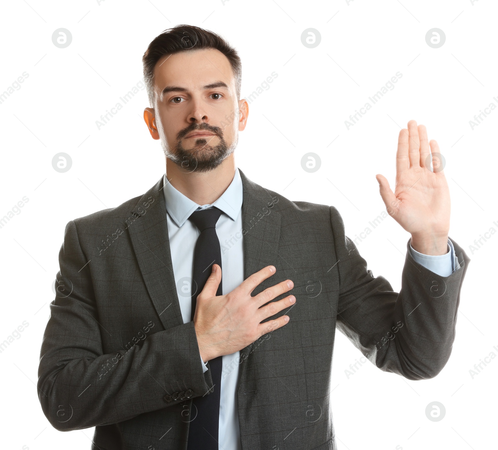 Photo of Man making promise with raised hand on white background. Oath gesture