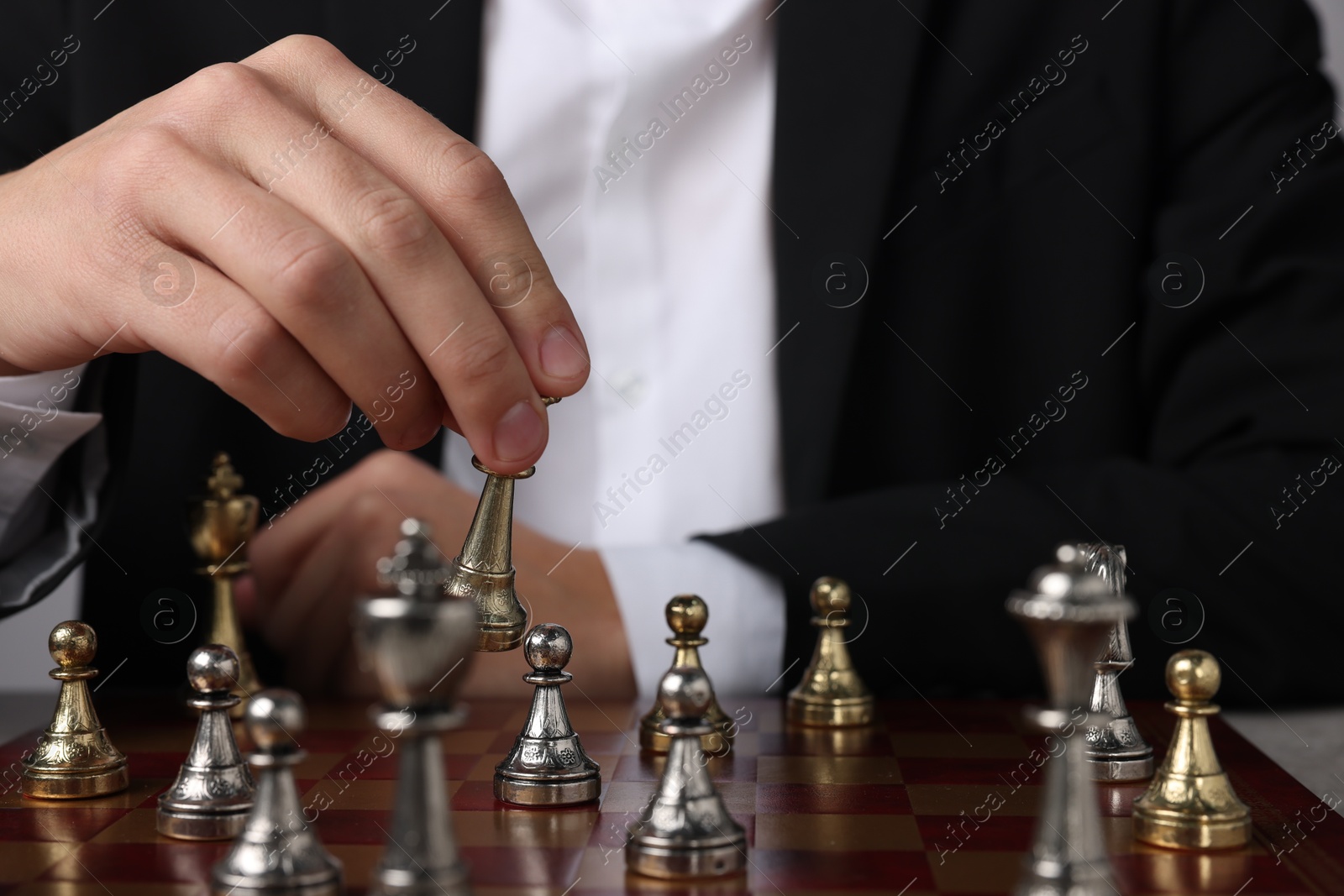 Photo of Businessman playing chess on chessboard, closeup. Competition concept