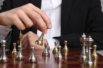 Photo of Businessman playing chess on chessboard, closeup. Competition concept